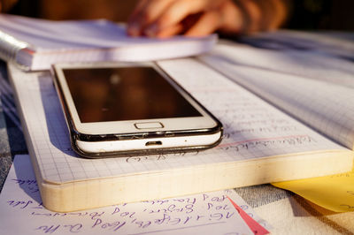 Close-up of mobile phone over book on table