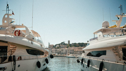 Boats moored in sea against clear sky