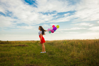 Full length of woman with umbrella standing on field