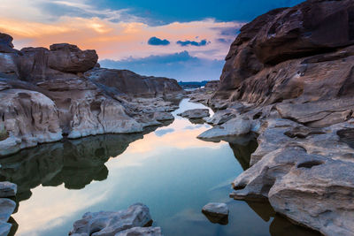 Scenic view of rocks and mountains against sky during sunset