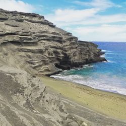 Rock formations on beach against sky