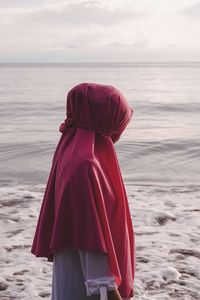 Rear view of woman looking at sea against sky