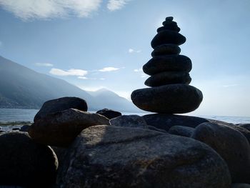 Stack of stones on beach against sky