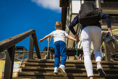 Low angle view of father and son walking on staircase