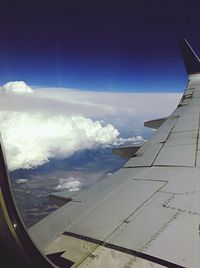 Cropped image of airplane wing over landscape