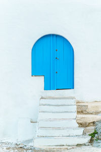 Vertical view of white stairs and blue door with nobody. summer travel destination in spain.
