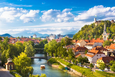 River amidst buildings in city against sky