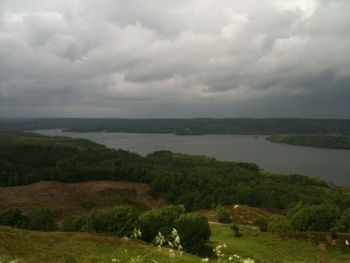 Scenic view of calm lake against cloudy sky