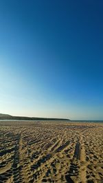 Scenic view of desert against clear blue sky