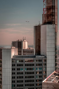 Modern buildings in city against sky during sunset