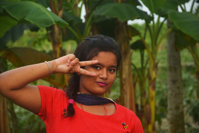 Portrait of smiling young woman against plants