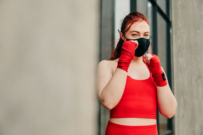 Full length of woman standing against wall