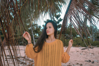 Portrait of young woman standing at beach