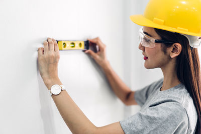 Portrait of woman working on wall