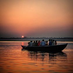 Boats in sea at sunset