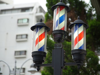 Tricolored sign in front of a japanese barbershop
