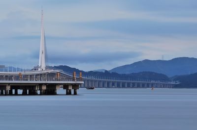 View of bridge over river against cloudy sky