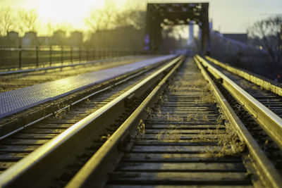 Railroad tracks on bridge over river at sunset 