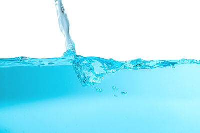 Close-up of water splashing against blue background