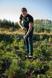 Male worker digging ground on farm