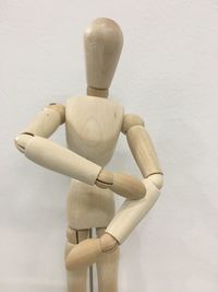 Wooden figurine against wall