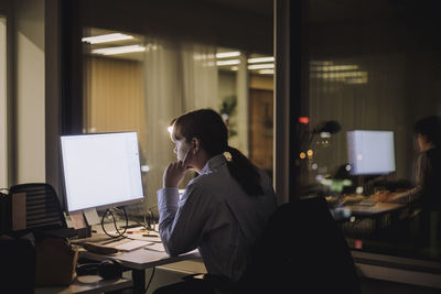 Young businesswoman concentrating while working on computer in office at night