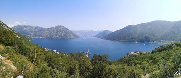 Scenic view of lake and mountains against clear blue sky