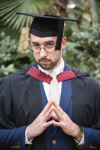 Midsection of man wearing graduation gown