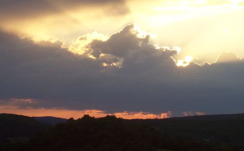 Scenic view of dramatic sky over silhouette landscape