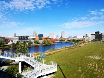 Scenic view of river by buildings against sky