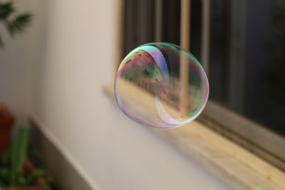 Close-up of soap sud bubble with reflection of buildings