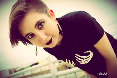 Close-up portrait of young woman against sky