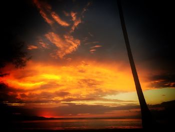 Scenic view of sea against dramatic sky during sunset