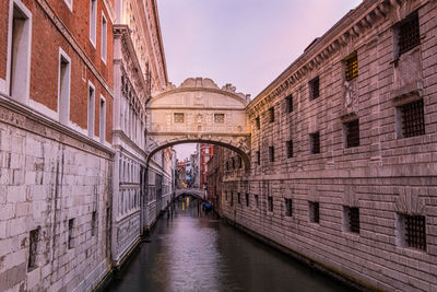 Bridge over canal amidst buildings in city
