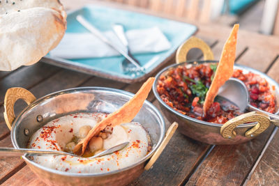 High angle view of hummus and spicy tomato salad on table