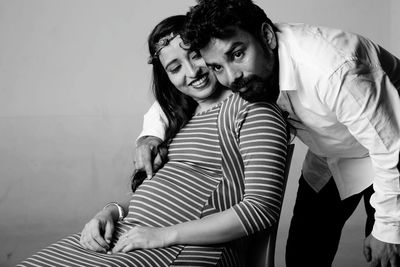 Man embracing pregnant woman at home
