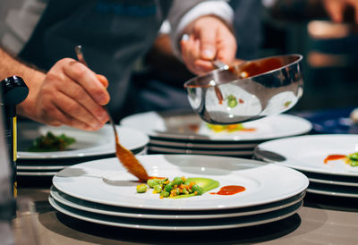 Midsection of chef garnish food in restaurant