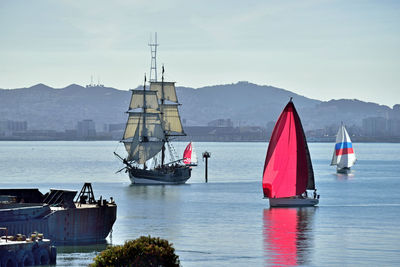 Boats sailing in sea against sky