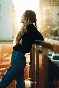 Side view of young woman standing in balcony