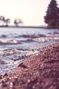 Surface level of sea shore against clear sky