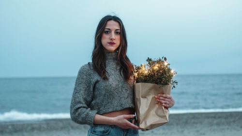 Girl on the beach with a shopping bag of lights