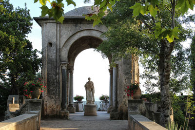 Statue amidst plants against sky