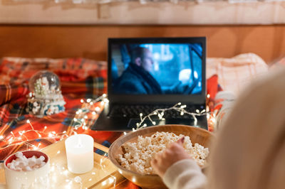 Woman's hand with popcorn and watching the move