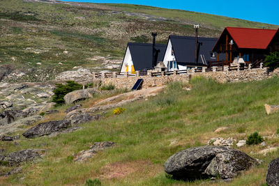 Houses on field against mountain