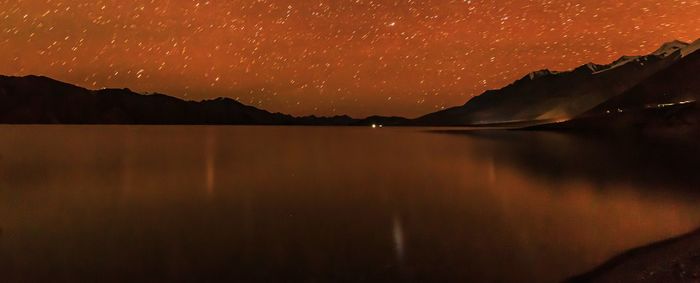 Scenic view of lake against sky at night