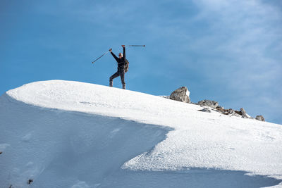 Man standing on snowcapped mountain against sky