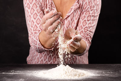 Midsection of woman with knife on table