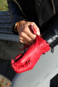 Midsection of woman wearing red glove in sunny day