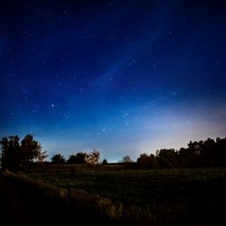 Scenic view of silhouette field against clear sky at night