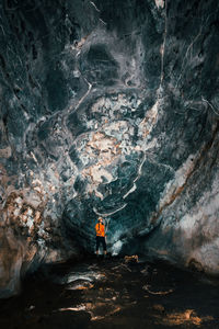 Rear view of man standing in cave